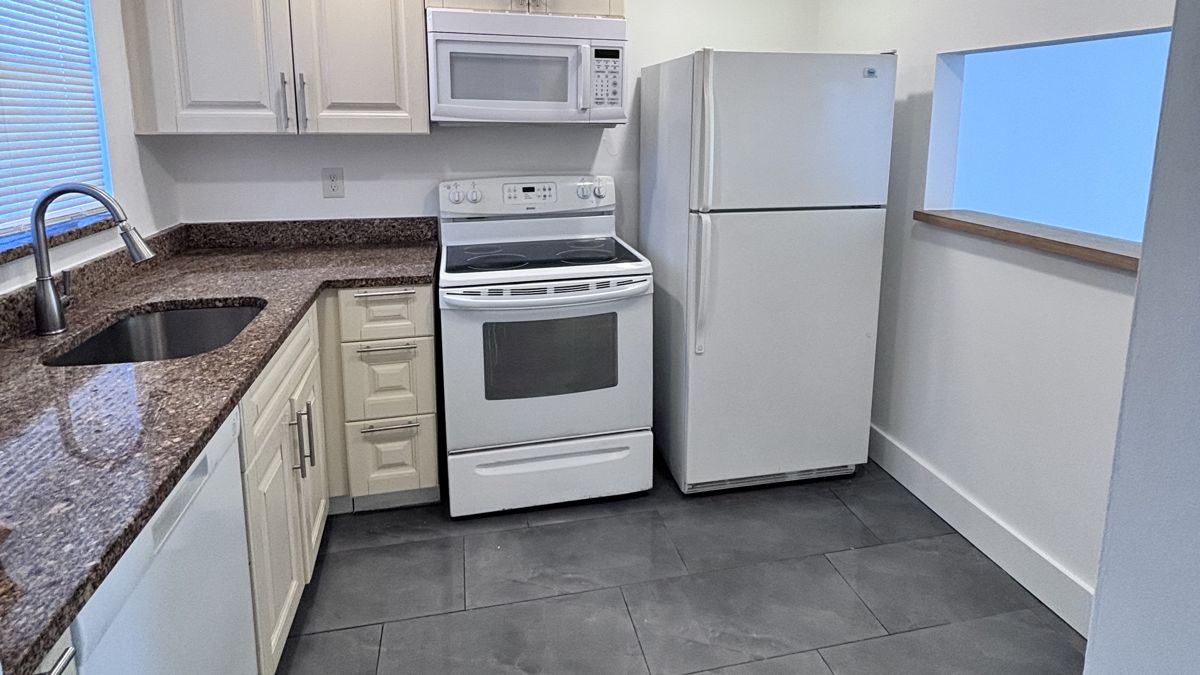 Updated kitchen with granite counters and large gray tile floor, 6850 Royal Palm Blvd #104, Margate